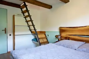 z ložnice s dvojlůžkem vedou příkré schody do otevřené podkrovní ložnice s dvojlůžkem