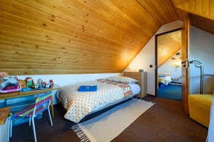 průchozí ložnice s lůžkem o šířce 110 cm pro 1 osobu a rozkládacím křeslem v podkroví