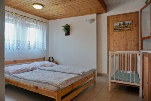 ložnice s dvojlůžkem a dětskou postýlkou