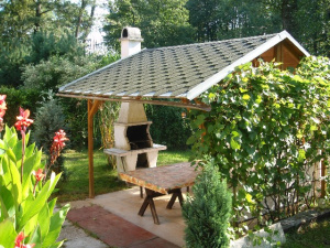 U chaty je k dispozici pergola s venkovním posezením a zahradním krbem