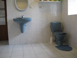 Koupelna je vybavena rohovou vanou, WC a umyvadlem