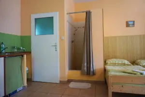 sprchový kout je součástí pokoje chaty, za dveřmi se nachází samostatné WC s umyvadlem
