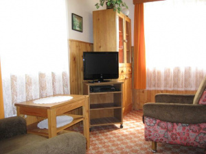 Na kuchyni navazuje malý obytný pokoj s posezením a TV