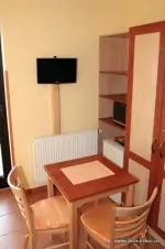 pokoj apartmánu - stůl, židle a TV