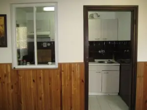 Z obytné místnosti se vstupuje do malé kuchyňky