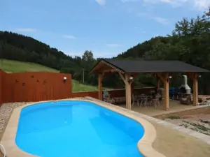 Hned u bazénu se nachází pergola s venkovním posezením