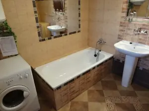koupelna je vybavena vanou, umyvadlem, pračkou a WC