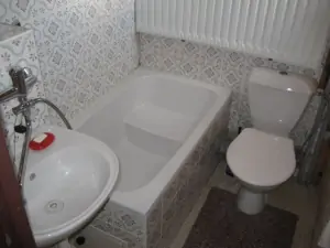 Koupelna v podkroví je vybavena malou vanou, WC a umyvadlem
