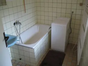 Koupelna je vybavena vanou, umyvadlem a pračkou