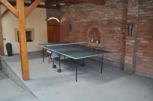 zastřešená část dvora s lavicemi a stolním tenisem