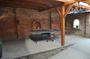 zastřešená část dvora s lavicemi a stolním tenisem