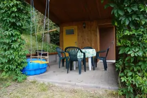 zastřešená terasa se zahradním nábytkem za chatou