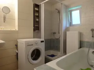 Koupelna se sprchovým koutem, vanou, pračkou a umyvadlem