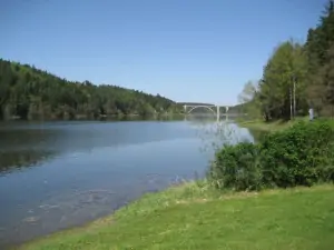 Orlická přehrada je od chaty vzdálena 200 m (v dálce Podolský most)