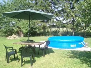 venkovní posezení se slunečníkem u bazénu