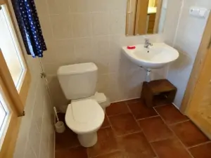 Koupelna v přízemí je vybavena vanou, WC a umyvadlem