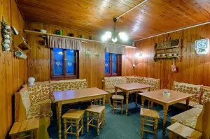 společenská místnost s jídelním prostorem, kachlovými krbovými kamny a barovým pultem