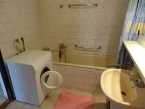 Koupelna v přízemí je vybavena vanou, WC, umyvadlem a pračkou